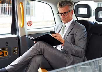 乘坐出租车的会员使用手机。
