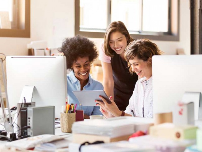 三名使用平板电脑和计算机进行网站设计的妇女